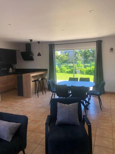 un salon avec une table bleue et des chaises dans l'établissement Les Ecrehous de Saint Jean, à Barneville-Plage