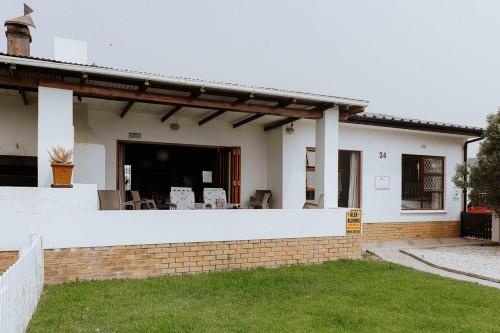 a white house with a brick wall at Moschel in Paternoster