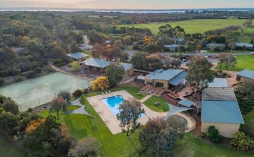 an aerial view of a home with a pool and a tennis court at Couple's Resort Spa Retreat in Cowes