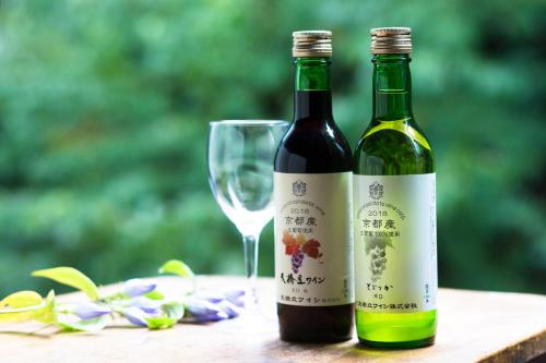 two bottles of wine next to a wine glass at Oyado Hisaya in Kami