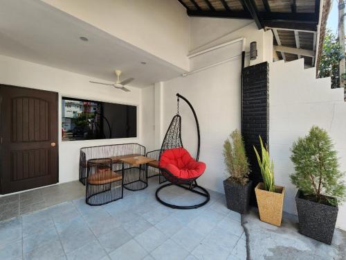 a patio with a swing and a table and chairs at Boxsoon nimman 8 # 3beds 2bahts in Chiang Mai