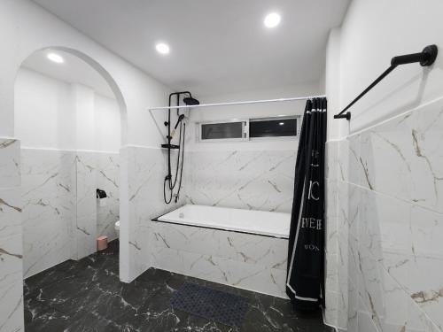 ein Bad mit einer Dusche mit einem schwarzen Duschvorhang in der Unterkunft Boxsoon nimman 8 in Chiang Mai