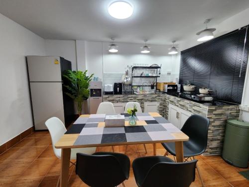 Una cocina con una mesa y sillas en una cocina. en Boxsoon nimman 8 # 3beds 2bahts, en Chiang Mai