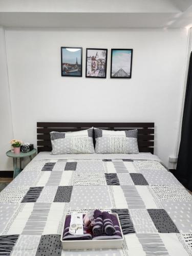 a bedroom with a large bed with a checkered blanket at Boxsoon nimman 8 # 3beds 2bahts in Chiang Mai
