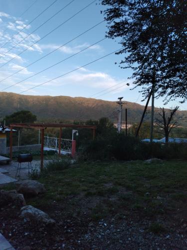 a yard with a chair and a fence and mountains at Casa de montaña in Bialet Massé