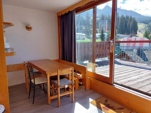 Cette chambre dispose d'un balcon avec une table et des chaises en bois. dans l'établissement Appartement 3 pièces pour 7 personnes, proche pistes, commerces et ESF, avec terrasse, Les Arcs 1800 - FR-1-411-395, à Bourg-Saint-Maurice