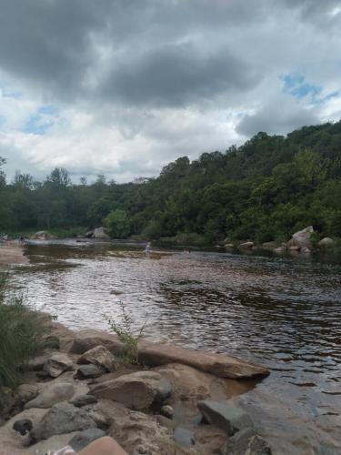 a body of water with people on the shore at Casa de montaña in Bialet Massé