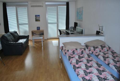 布拉格的住宿－候基舒服斯卡停車位公寓，一间卧室配有一张床、一张沙发和一张书桌