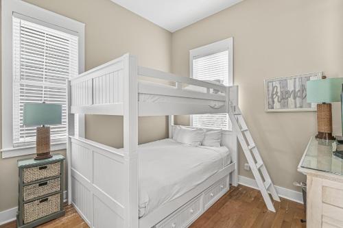 a white bunk bed in a room with windows at Shore Fun At Destin Pointe Resort in Destin