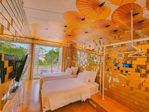 two beds in a room with umbrellas on the ceiling at Little Shelter Hotel Chiangmai SHA Plus in Chiang Mai
