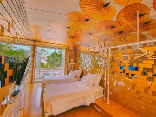 two beds in a room with umbrellas on the ceiling at Little Shelter Hotel Chiangmai in Chiang Mai