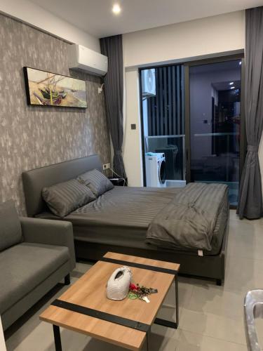 a bedroom with a bed and a couch and a table at 21B No.1 Best Location In Phnom Penh Capital, Swimming Pool & Gyms in Phnom Penh