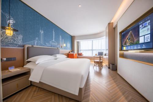 a hotel room with a large bed and a tv at Guangzhou Baiyun Airport MeHood Liz Hotel T1 Free Shuttle Bus in Guangzhou