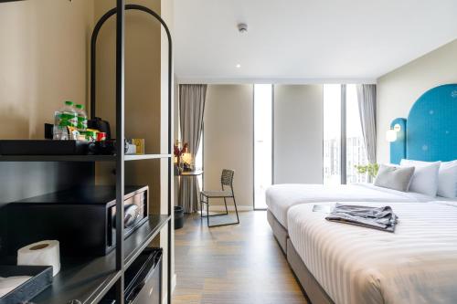 a hotel room with a bed and a large window at Benjarong Hotel Bangkok in Ban Zong Katiam
