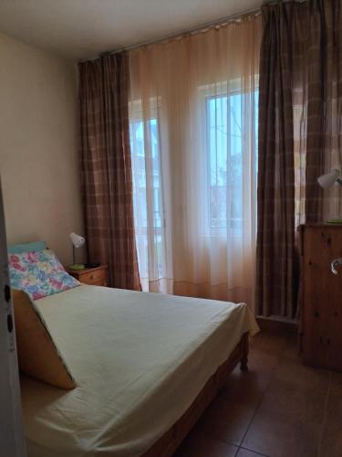 sypialnia z łóżkiem i oknem w obiekcie Sinemorets apartment w mieście Sinemorec