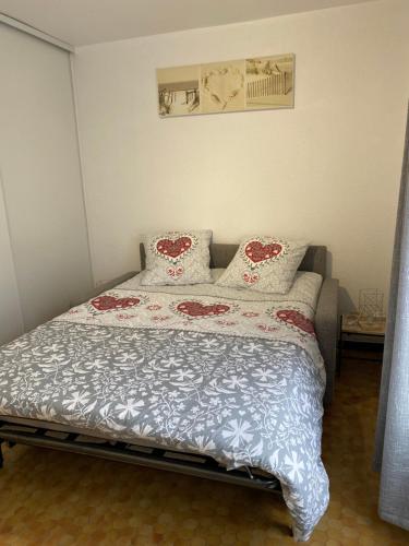 une chambre avec un grand lit avec des oreillers dessus dans l'établissement Au cœur de la Cotinière Studio en résidence parking privé wifi, à La Cotinière