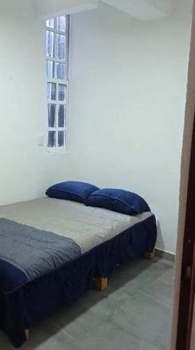 a bedroom with two beds and a window at Departamentos La Angosta in Acapulco