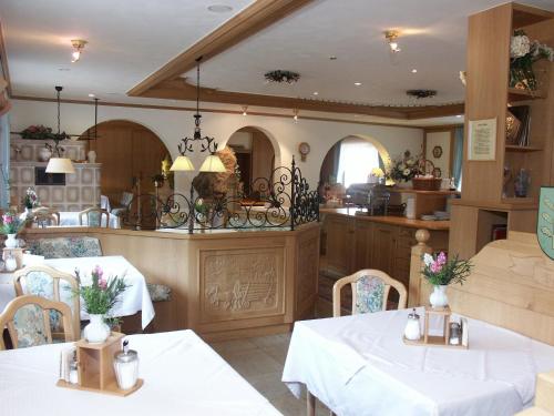 a dining room with two tables and a kitchen at Wald-Hotel Heppe in Dammbach