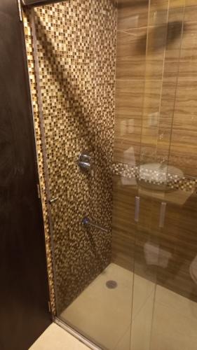 um chuveiro com uma porta de vidro na casa de banho em Departamento 2B en Condominio La Victoria em Cuenca