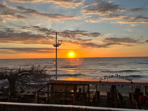 una puesta de sol en la playa con la puesta de sol sobre el océano en Studio bord de mer en San-Nicolao