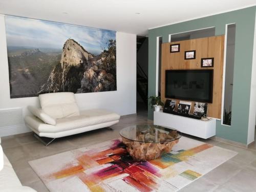 ein Wohnzimmer mit einem Sofa und einem TV in der Unterkunft TRES BELLE VILLA CONTEMPORAINE in Causse-de-la-Selle