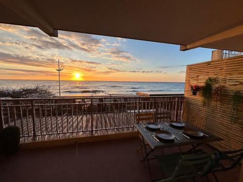 balcón con mesa y vistas al océano en Studio bord de mer, en San-Nicolao