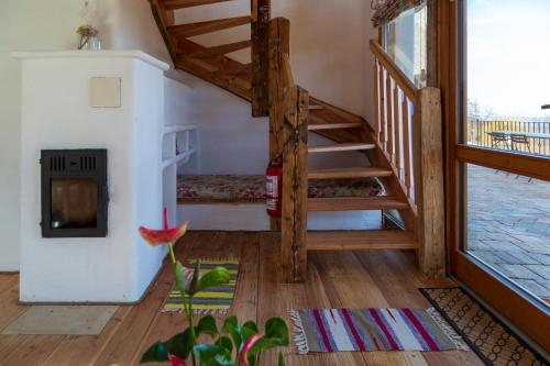 a living room with a staircase and a fireplace at Casele cu Stuf B&B Haus Ulrike in Sălicea
