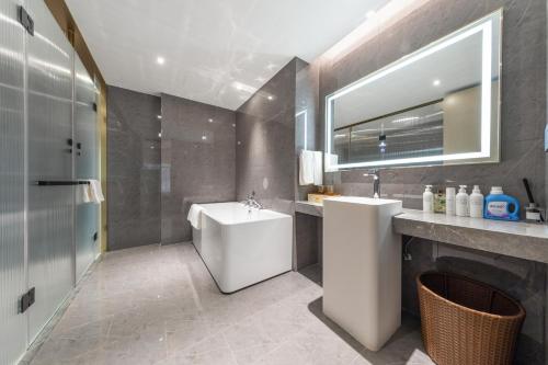 a bathroom with a sink and a toilet and a mirror at Guangzhou Baiyun Airport MeHood Liz Hotel Free Shuttle Bus to Canton Fair and to Airport in Guangzhou