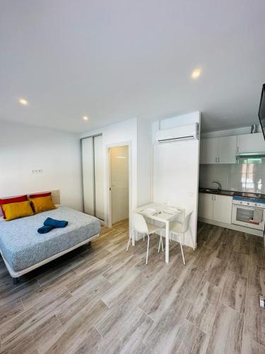 ein Schlafzimmer mit einem Bett und einem Tisch sowie eine Küche in der Unterkunft MINI ESTUDIOS SANSE in San Sebastián de los Reyes