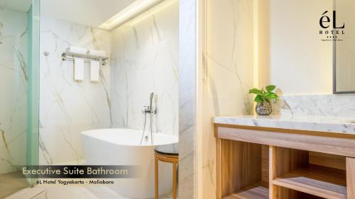 a bathroom with a white sink and a tub at eL Hotel Yogyakarta Malioboro in Yogyakarta