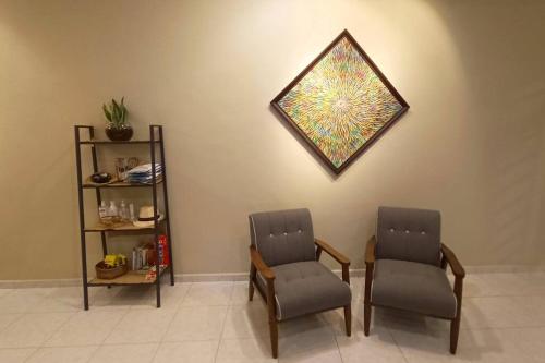a waiting room with two chairs and a picture on the wall at A Simple One in Muar