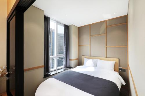 Un dormitorio con una cama grande y una ventana en The Stay Classic Hotel Myeongdong en Seúl