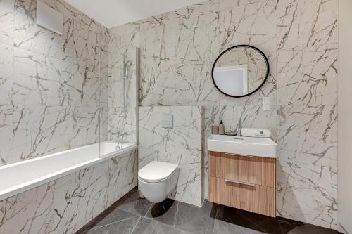 een badkamer met een wastafel, een toilet en een spiegel bij Lion Apartments - Gdynia City Center Bank Polski in Gdynia