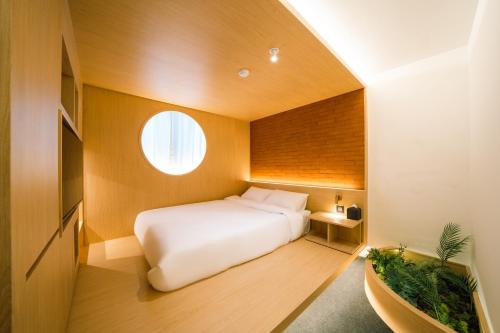 una piccola camera con un letto bianco e una finestra di Y Collection by Unboundi Gyeongju a Gyeongju