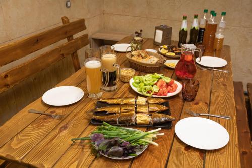 a wooden table with plates of food and drinks at Alaska Resort in Tsaghkadzor