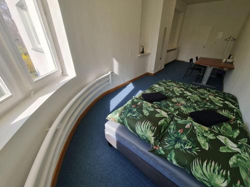 ein Schlafzimmer mit einem Bett mit einer grünen Bettdecke in der Unterkunft Fantastic Mokotow - FMG Pokoj M in Warschau