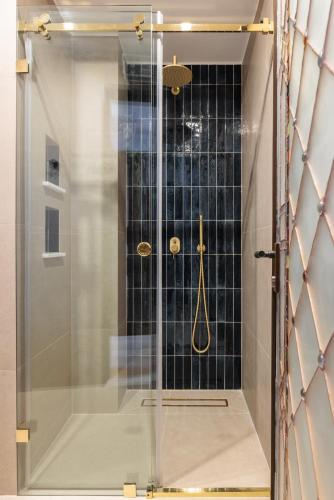 a shower with a glass door in a bathroom at Αρχοντικό Κίτσου - BOUTIQUE HOTEL in Kastoria