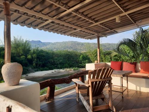 a porch with a table and chairs and a view at Pingplalee Resort in Sai Yok