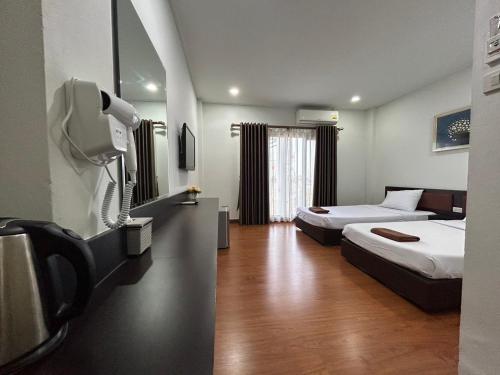 a hotel room with two beds and a tv at Bordin Hotel in Ubon Ratchathani