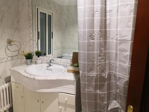 a bathroom with a sink and a shower curtain at Casa Riera * En el centro de Oviedo, terraza, 2Hab in Oviedo