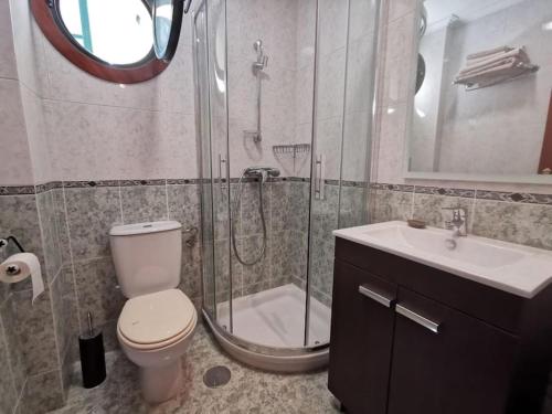 uma casa de banho com um chuveiro, um WC e um lavatório. em P° Olmos, Panxón, bajo con jardín privado em Nigrán