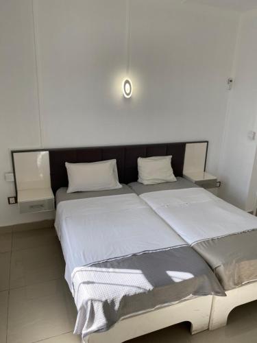 a bedroom with a large bed with white sheets at Residence La Colombe in Grand Baie