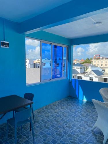 a balcony with blue walls and a table and chairs at Residence La Colombe in Grand Baie