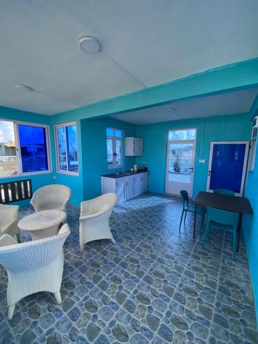 a living room with blue walls and a table and chairs at Residence La Colombe in Grand Baie