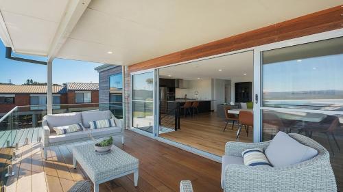 a living room with furniture and a balcony at Unit 2 10 Cliff Street Merimbula in Merimbula