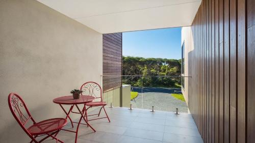 a room with a table and chairs and a balcony at Unit 2 10 Cliff Street Merimbula in Merimbula