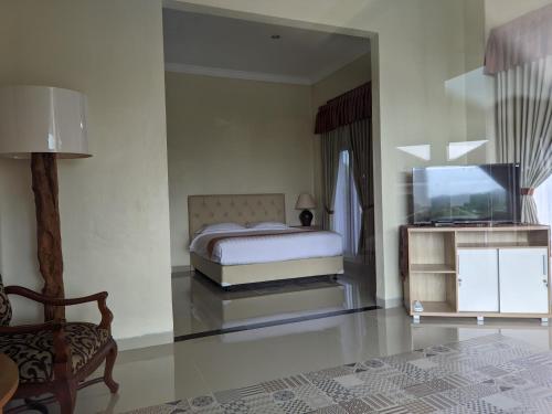 a bedroom with a bed and a flat screen tv at Djembar Inn in Kalasan