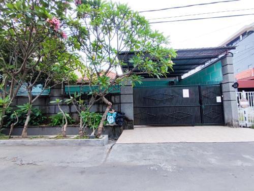 a person sitting in front of a black gate at Homey Guesthouse Kertajaya (Syariah) in Surabaya
