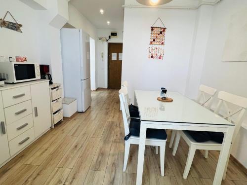 uma cozinha e sala de jantar com uma mesa branca e cadeiras em Sea View Studio em Constança