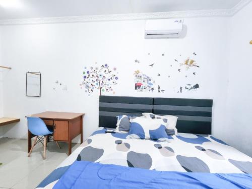 1 dormitorio con cama, mesa y escritorio en Homey Guesthouse Kertajaya (Syariah), en Surabaya